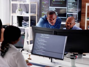 African Business Team Working On Computer. Software App Development