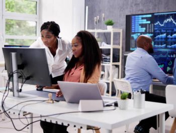 African Financial Data Analysts Using Performance Dashboard On Screens In Office